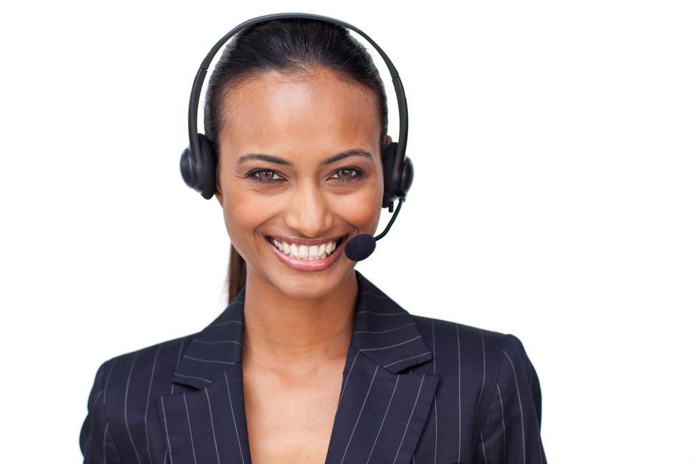 Portrait of a beautiful ethnic businesswoman with a headset on smiling at the camera